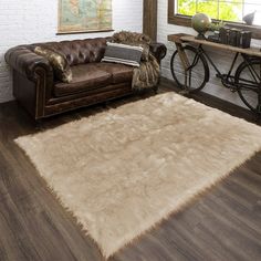 a living room with a brown leather couch and white rug