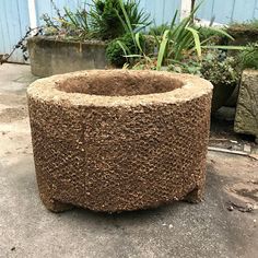 a planter made out of cement sitting on the ground