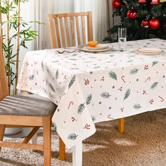 a dining room table with a christmas tree in the background