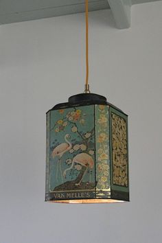 a lamp hanging from the ceiling in a room with a painting on it's side