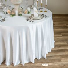 the table is set with white linens and silverware