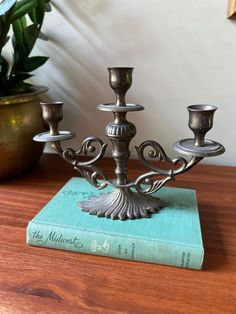 a metal candelabra sitting on top of a book