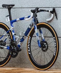 a close up of a bike parked against a wall with wheels on the front and rear