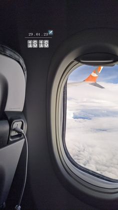 an airplane window looking out at the clouds