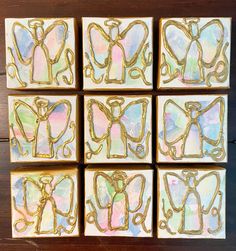 six square coasters with gold foil designs on them, sitting on a wooden surface