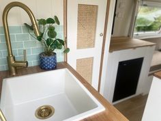 a white sink sitting under a kitchen faucet next to a wooden counter top