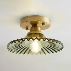 an antique brass ceiling light with glass shade