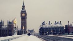 the big ben clock tower towering over the city of london covered in snow during winter