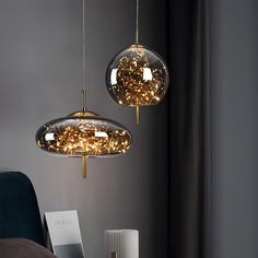 two circular lights hanging from the ceiling above a bed in a room with grey walls