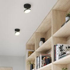 the bookshelves are filled with various types of books and plant pots on them