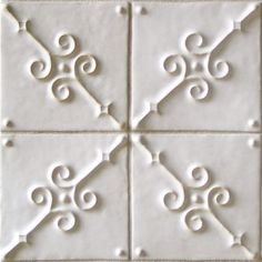 four white tiles with decorative designs on them