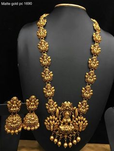 a gold necklace and matching earrings on display