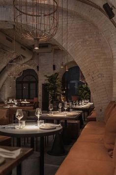 an empty restaurant with tables and couches in the center, along with wine glasses on the table