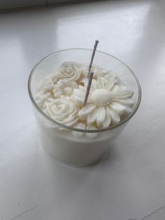 a glass bowl filled with white flowers on top of a table