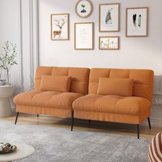 an orange couch sitting on top of a rug in a living room next to a white wall