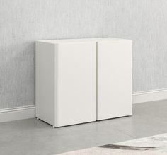 a white cabinet against a wall with a rug on the floor in front of it