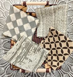 four pieces of cloth in a basket on a doily