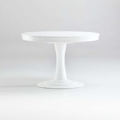 a white round table with pedestals on the top and bottom, against a plain background