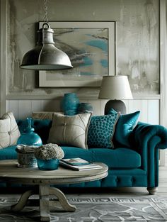 a living room filled with blue couches and pillows on top of a coffee table