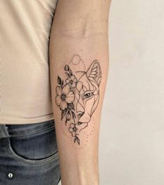 a woman's arm with a tattoo on it that has a wolf and flowers on it