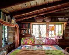 a bed in a room next to a window with bookshelves on the wall