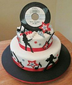 a birthday cake decorated with vinyl records and dancing stars on the top, is ready to be cut