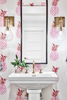 a white sink sitting under a mirror next to a wall mounted faucet in a bathroom