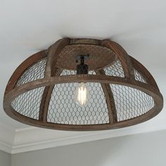 an old fashioned light fixture with chicken wire