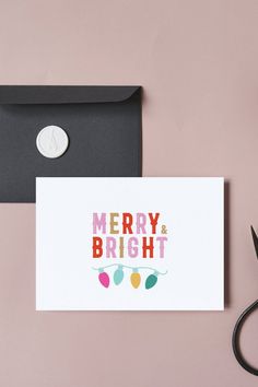 a merry and bright christmas card next to some scissors