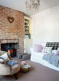 a living room filled with furniture and a fire place next to a book shelf full of books