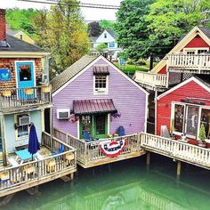 several colorful houses on stilts next to the water