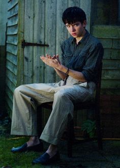 a man sitting in a chair with his hands together