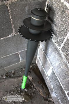 a hat on top of a pole in front of a brick wall