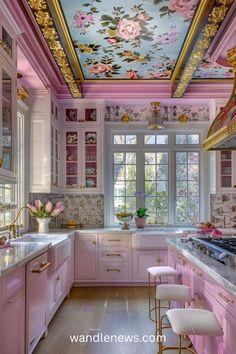 a kitchen with pink cabinets and gold trimmings on the ceiling is decorated with flowers