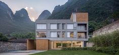 the house is surrounded by mountains and grass