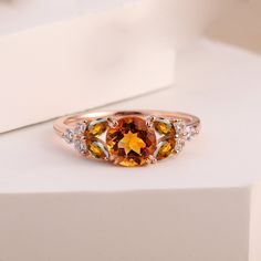 This Vintage Citrine Engagement Ring is a distinctive piece, featuring a vibrant citrine gemstone in a cluster design. Set in rose gold, it exudes a warm and elegant charm, perfect as a bridal or promise ring for women. The ring's unique design and customizable birthstone make it a special and personalized piece of jewelry. Ring Details Material: 14k Solid Gold Gold Color Options: White Gold, Yellow Gold, Rose Gold Center Stone: Nature Citrine  Stone Shape: Round cut 6.5mm Side Stones: Nature Ci Citrine Engagement Ring, Custom Birthstone Ring, Citrine Cluster, Citrine Ring Engagement, Cluster Design, Ring Rosegold, Engagement Ring Unique, Ring Rose Gold, Citrine Stone