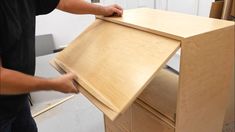 a man is working on a wooden cabinet