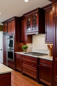 a large kitchen with wooden cabinets and stainless steel stove top oven in the center, surrounded by wood flooring