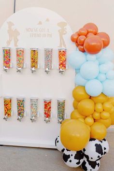 an assortment of candy and confetti displayed in front of a white display case