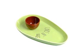 a green tray with a red bowl on it