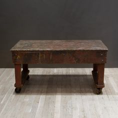 an old wooden bench sitting on top of a hard wood floor