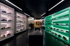 there are many shoes on the shelves in this store that is lit up with green lights