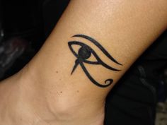 an eye tattoo on the back of a woman's arm, with black ink