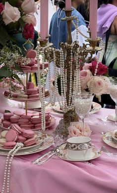 a table topped with lots of pink and white desserts