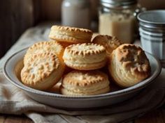 a white plate filled with cookies on top of a table next to a jar of peanut butter