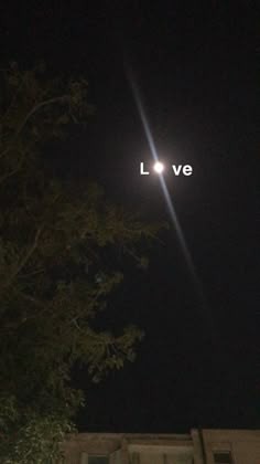 the words lve are lit up in the night sky above a building and trees