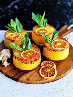 some oranges are sitting on a wooden plate with leaves and spices around them, ready to be eaten