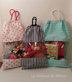 three bags with stuffed animals in them sitting on a table next to some books and toys