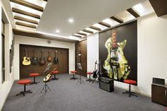 a room with guitars and stools in it