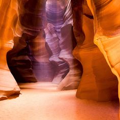 a narrow slot in the side of a rock formation with light coming from it's sides